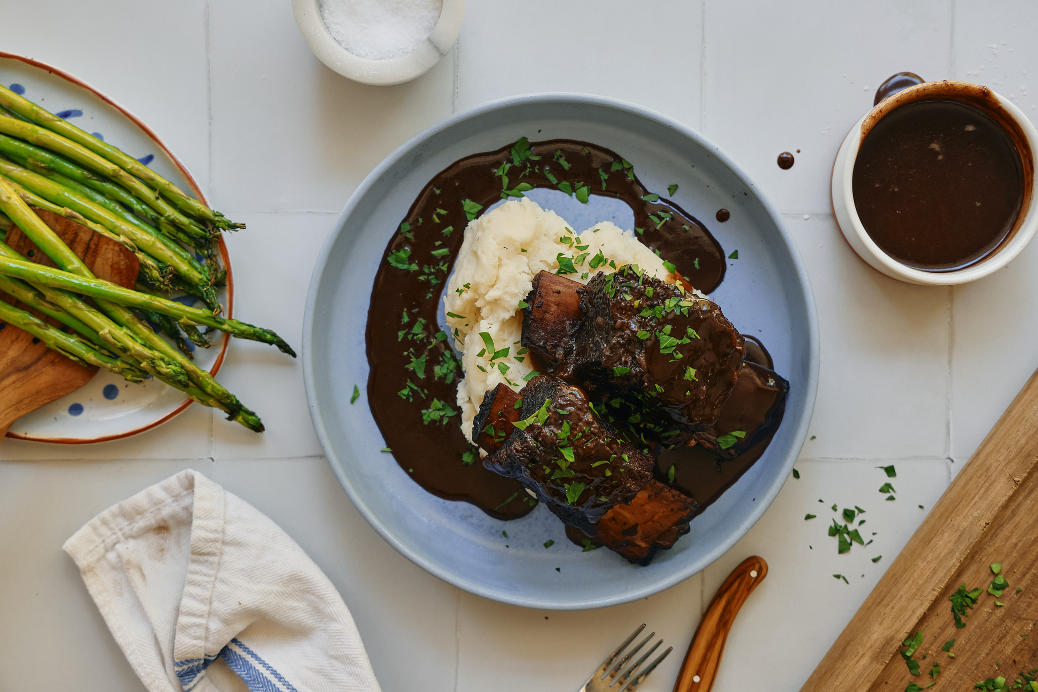 red wine braised short ribs over mashed potatoes, sautéed asparagus is in the photo on the left side