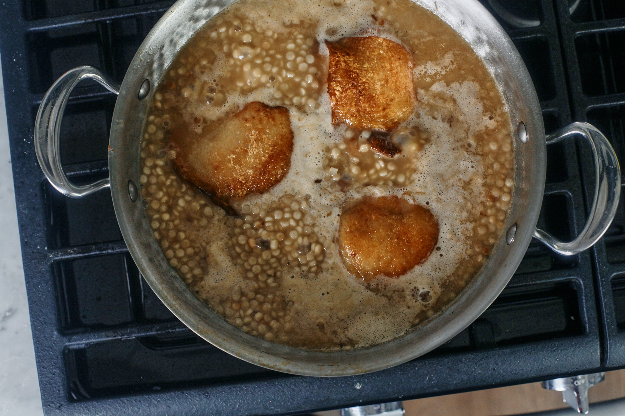 chicken thighs finishing cooking in the pearl couscous