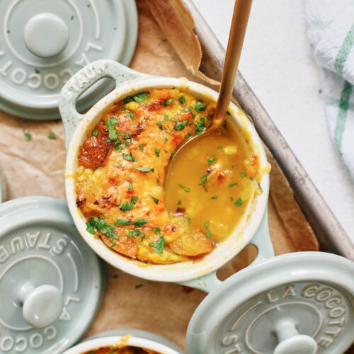 crocks of golden garlic soup after being broiled