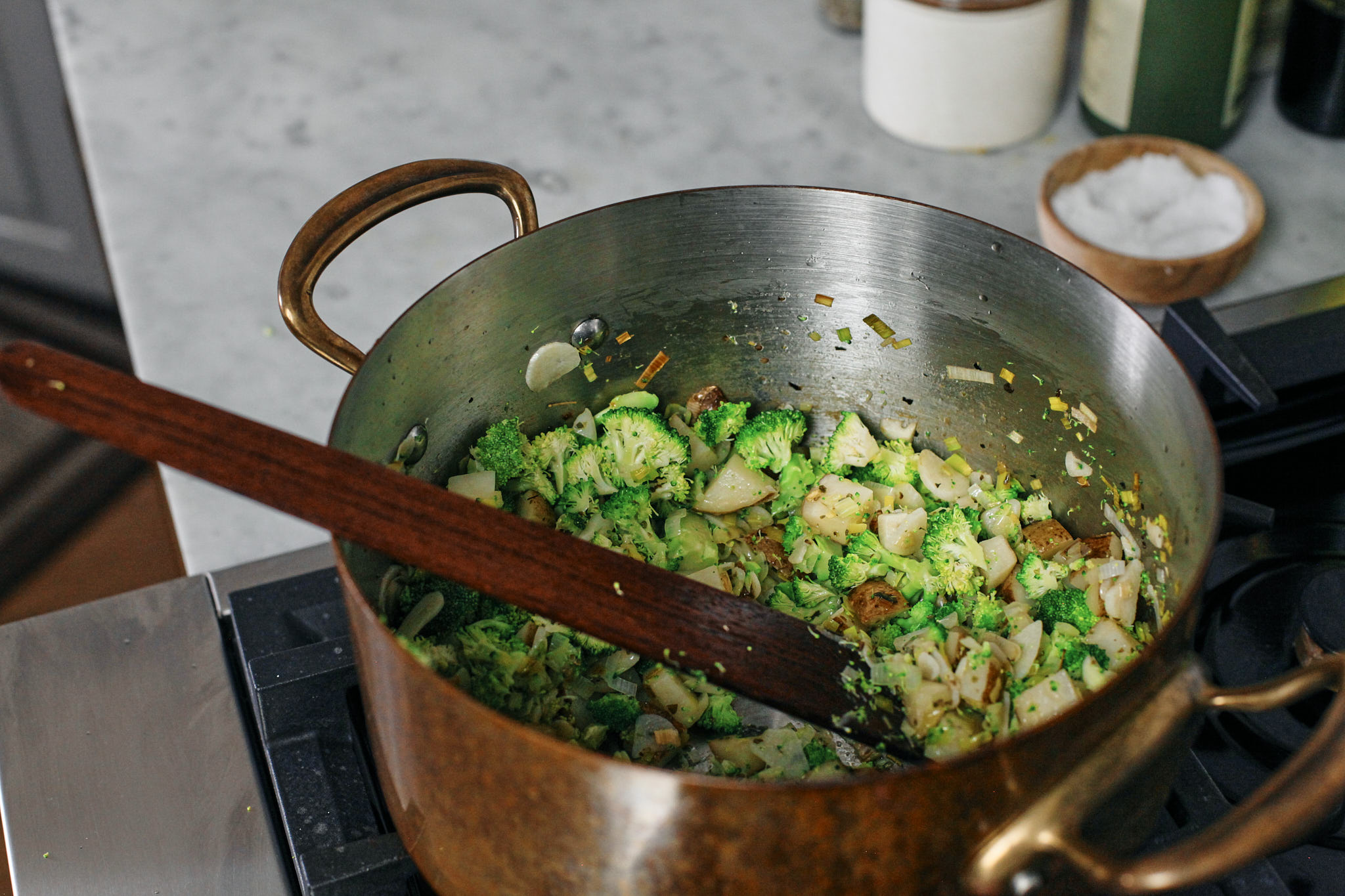 Mighty Greens Garlic Soup 5 potato, leek and garlic and broccoli sautéeing in butter and olive oil with some salt, pepper and marjoram seasoning.