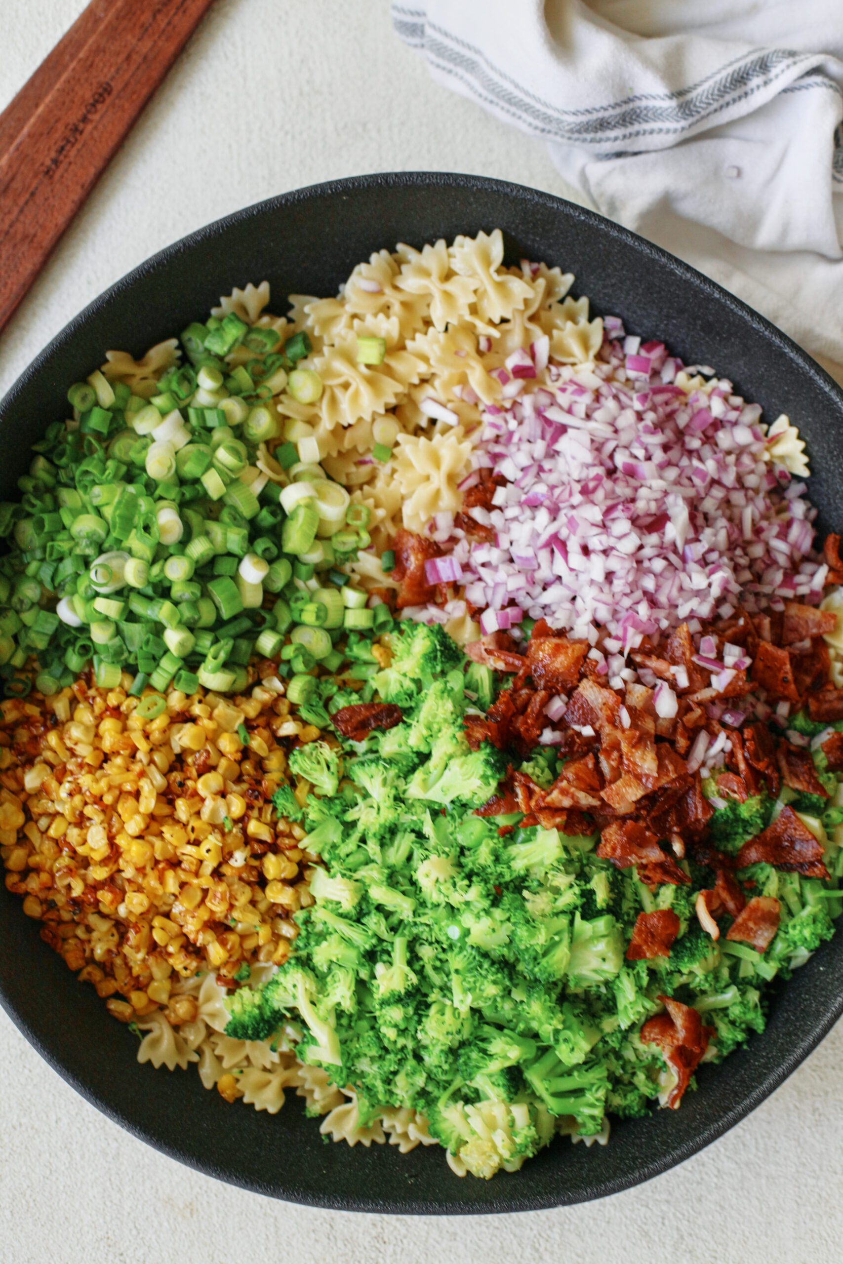 roasted corn bacon and broccoli pasta salad with green onions, red onion and farfalle