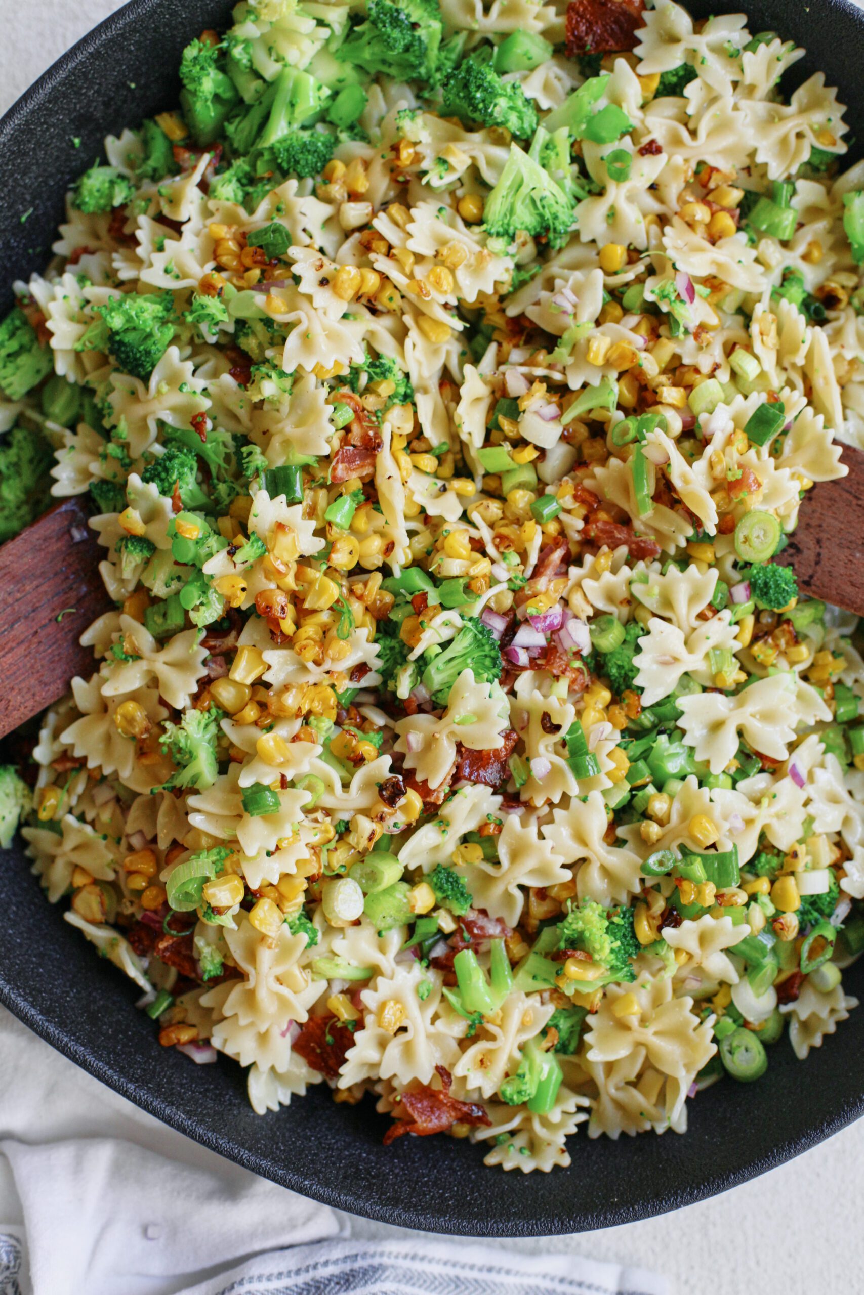 roasted corn bacon and broccoli pasta salad with green onions, red onion and farfalle