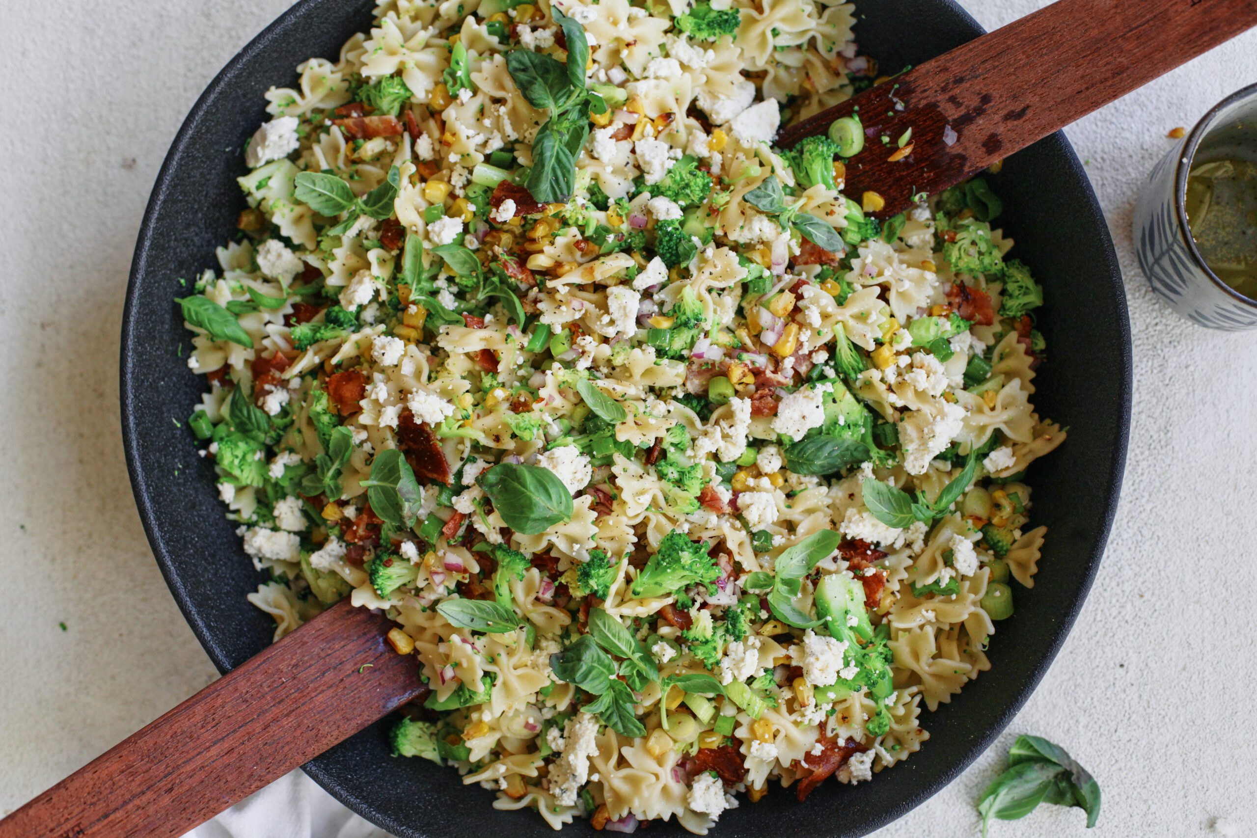 roasted corn bacon and broccoli pasta salad with green onions, red onion and farfalle