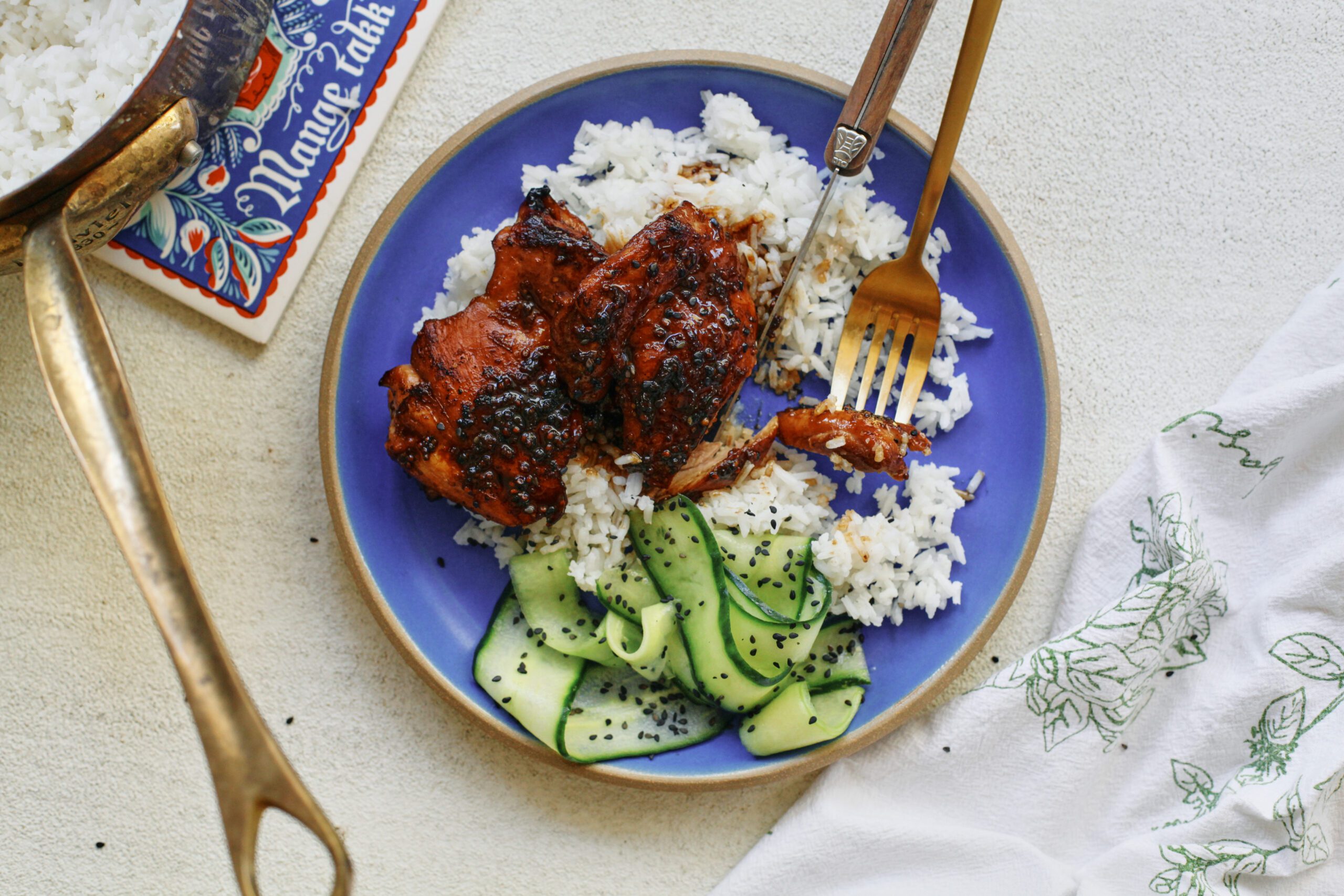 sticky sesame dijon chicken over rice with a cucumber salad