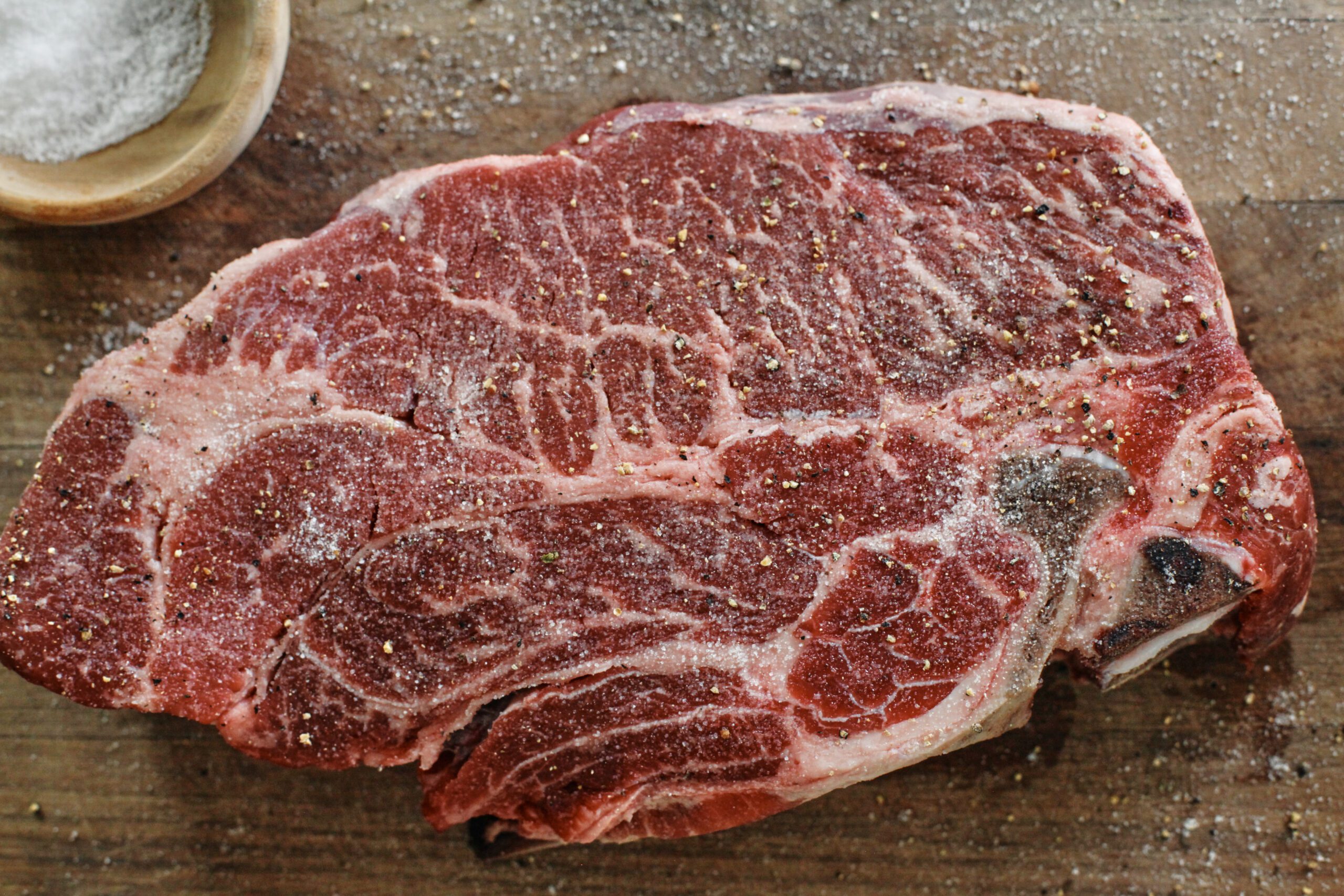 raw pot roast seasoned with salt and pepper