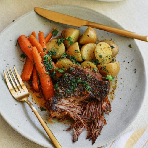 ale braised pot roast plated with baby potatoes and carrots