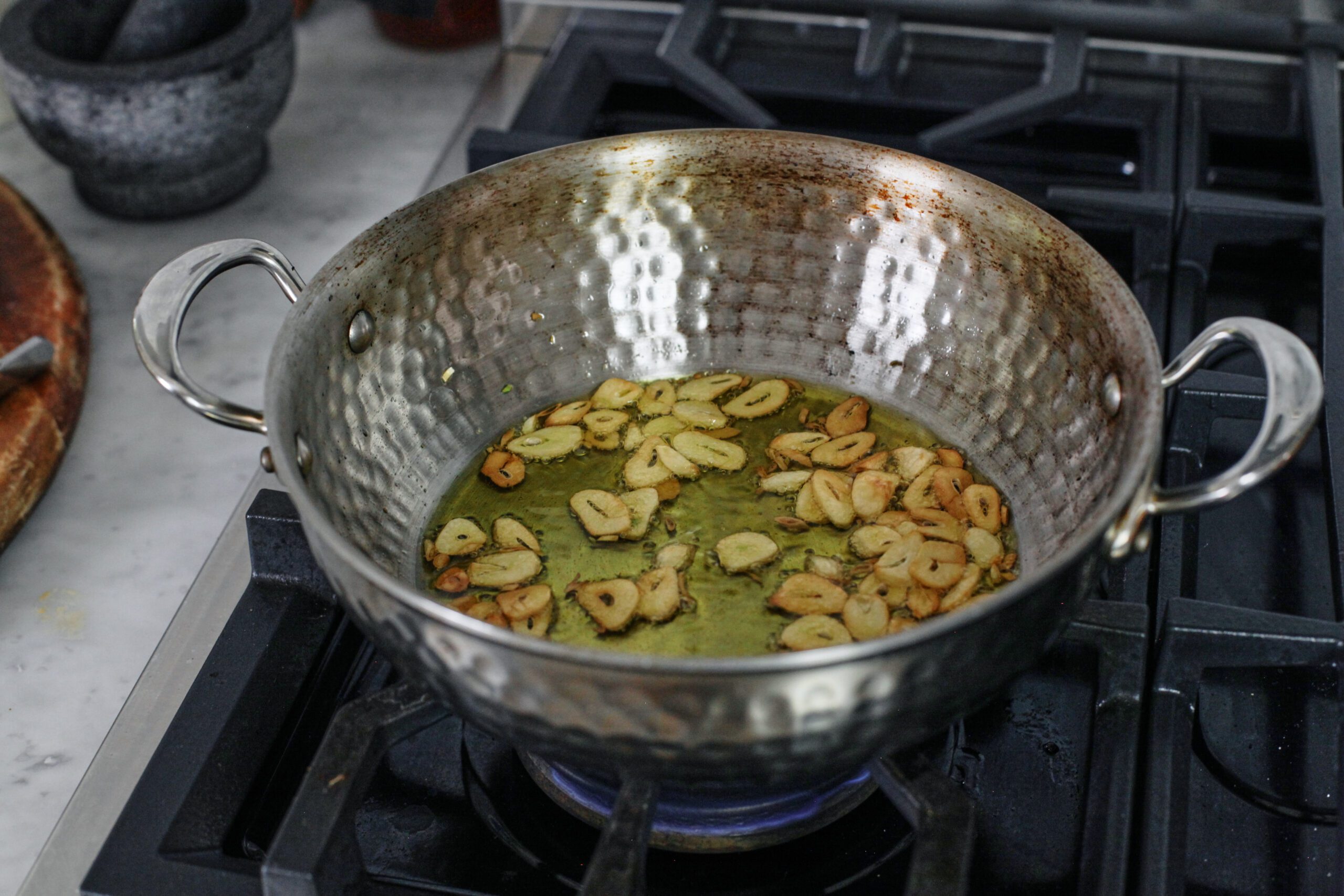 thin garlic slices frying in good quality olive oil until lightly golden