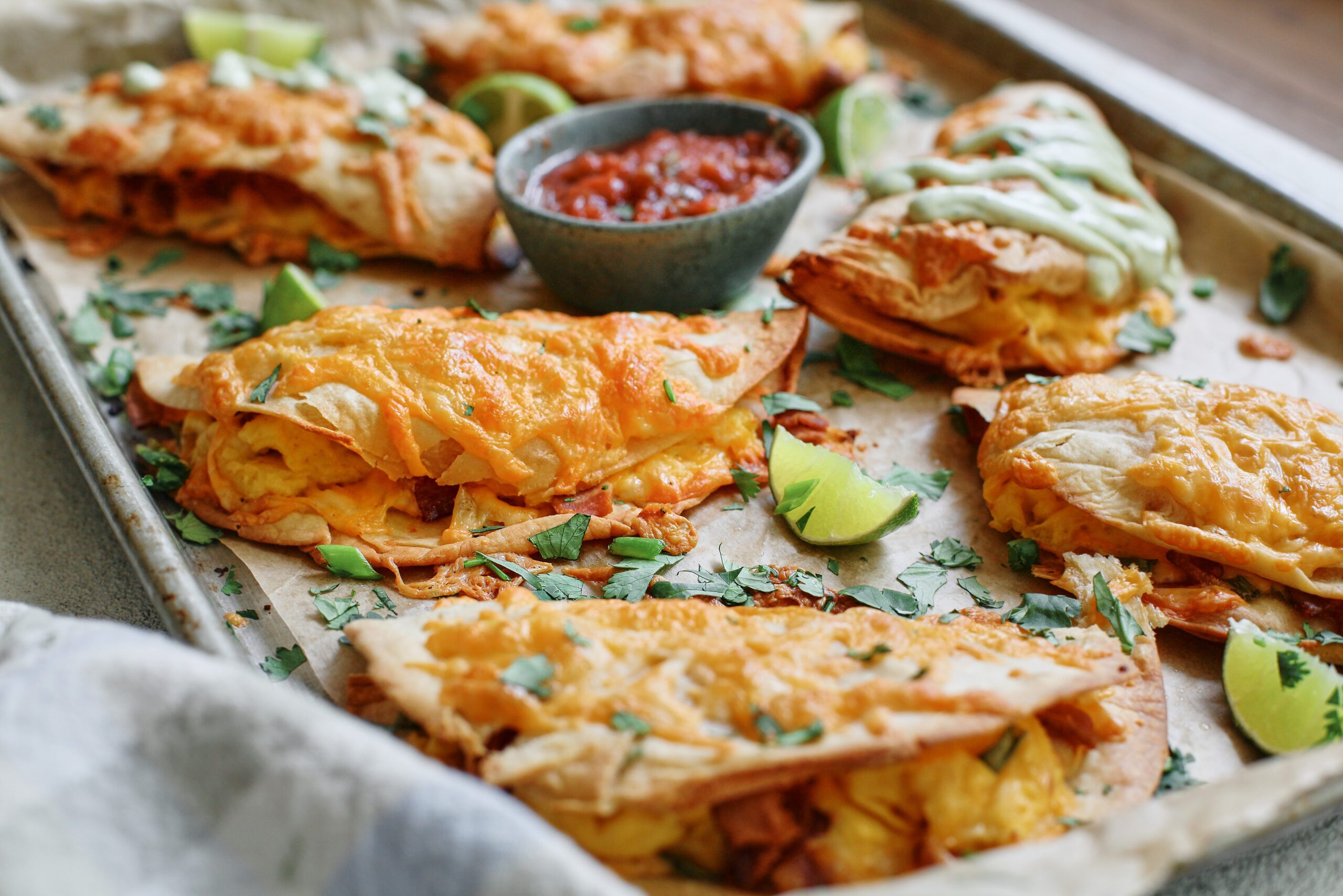 Bacon and Egg Sheet Pan Tacos drizzled with avocado lime crema