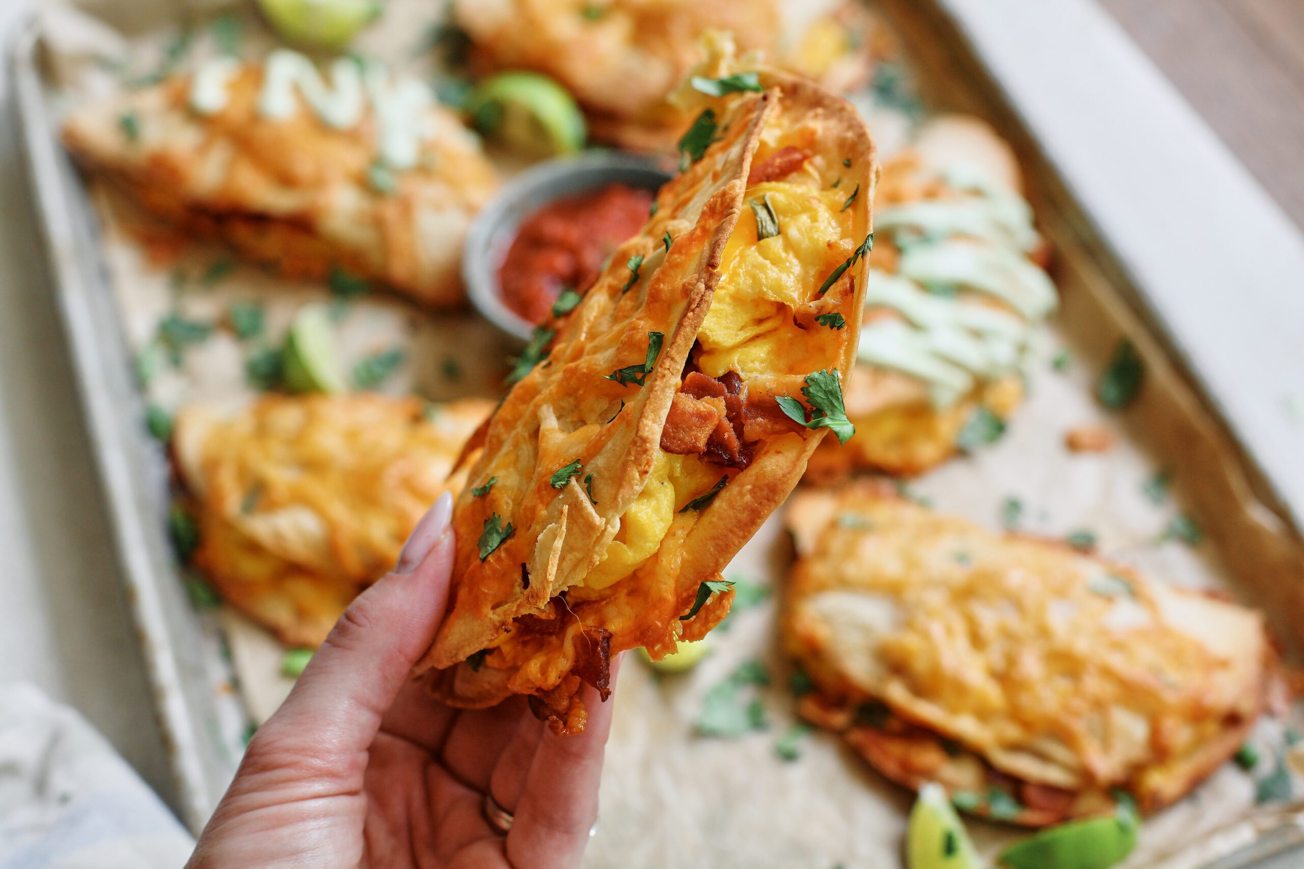 Bacon and Egg Sheet Pan Tacos 13 Hand holding a Bacon and Egg Sheet Pan Taco