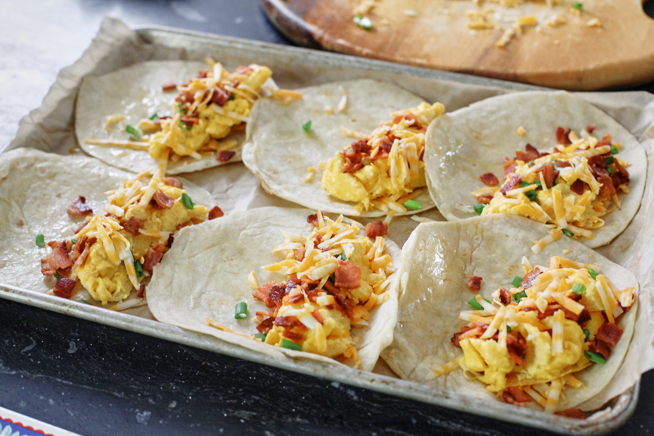 Bacon and Egg Sheet Pan Tacos 7 Bacon, eggs, green onion, colby jack shredded cheese on one half of 6 tortillas, arranged on a sheet pan.