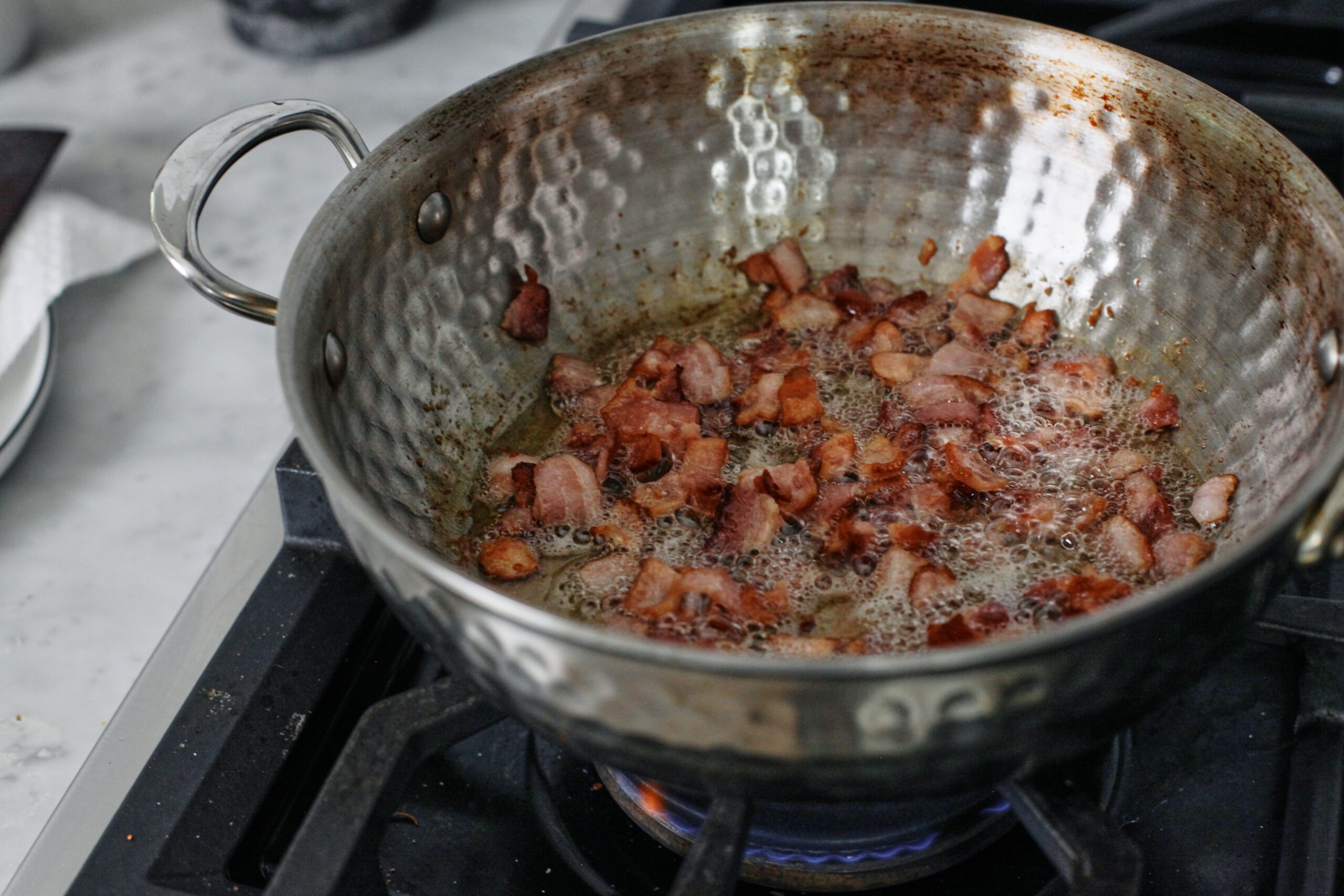 Bacon and Egg Sheet Pan Tacos Chopped bacon cooking in a pot on the stove