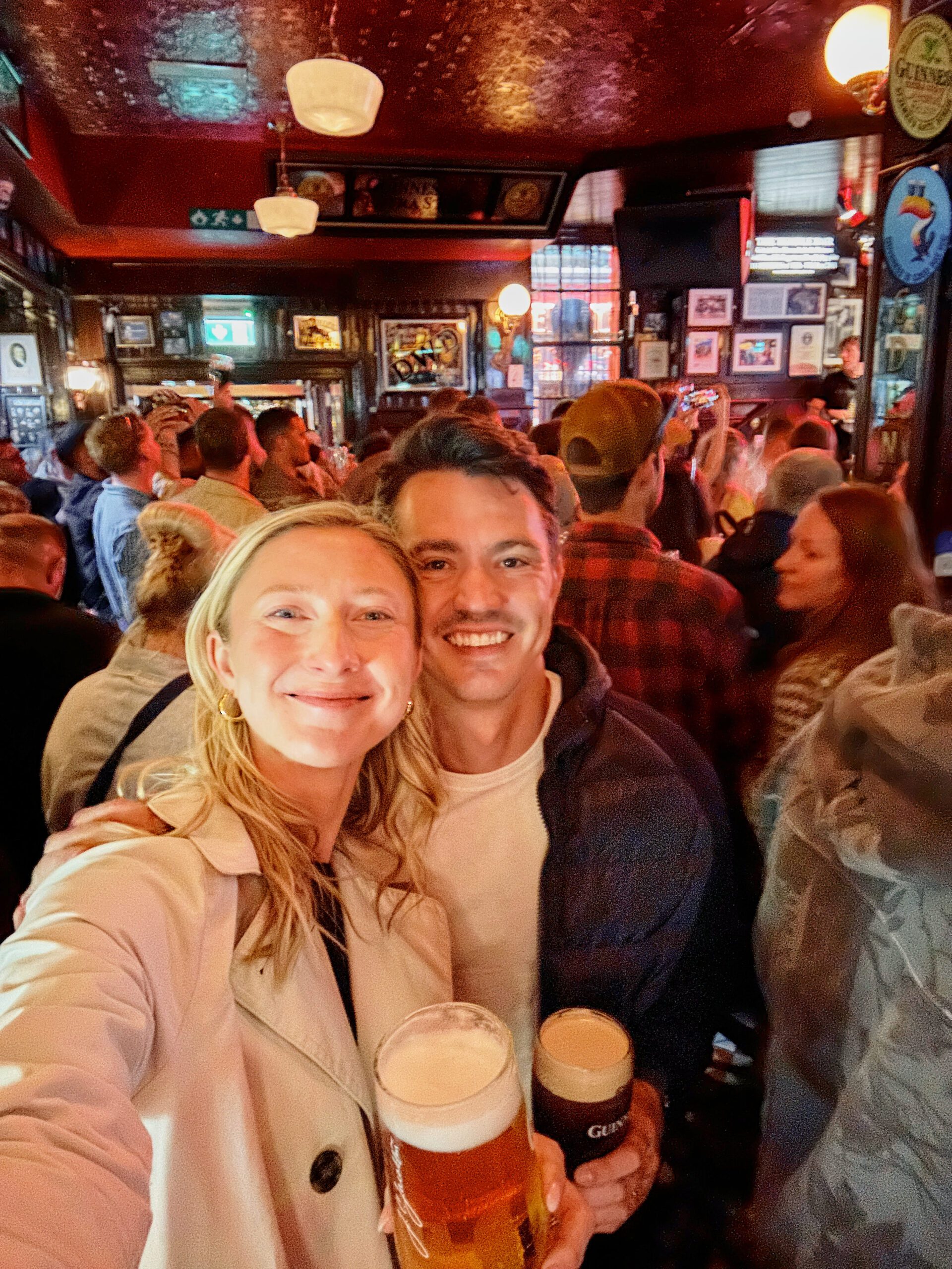 me, Brita (right) and my husband, Evan (left) both holding a pint of beer
