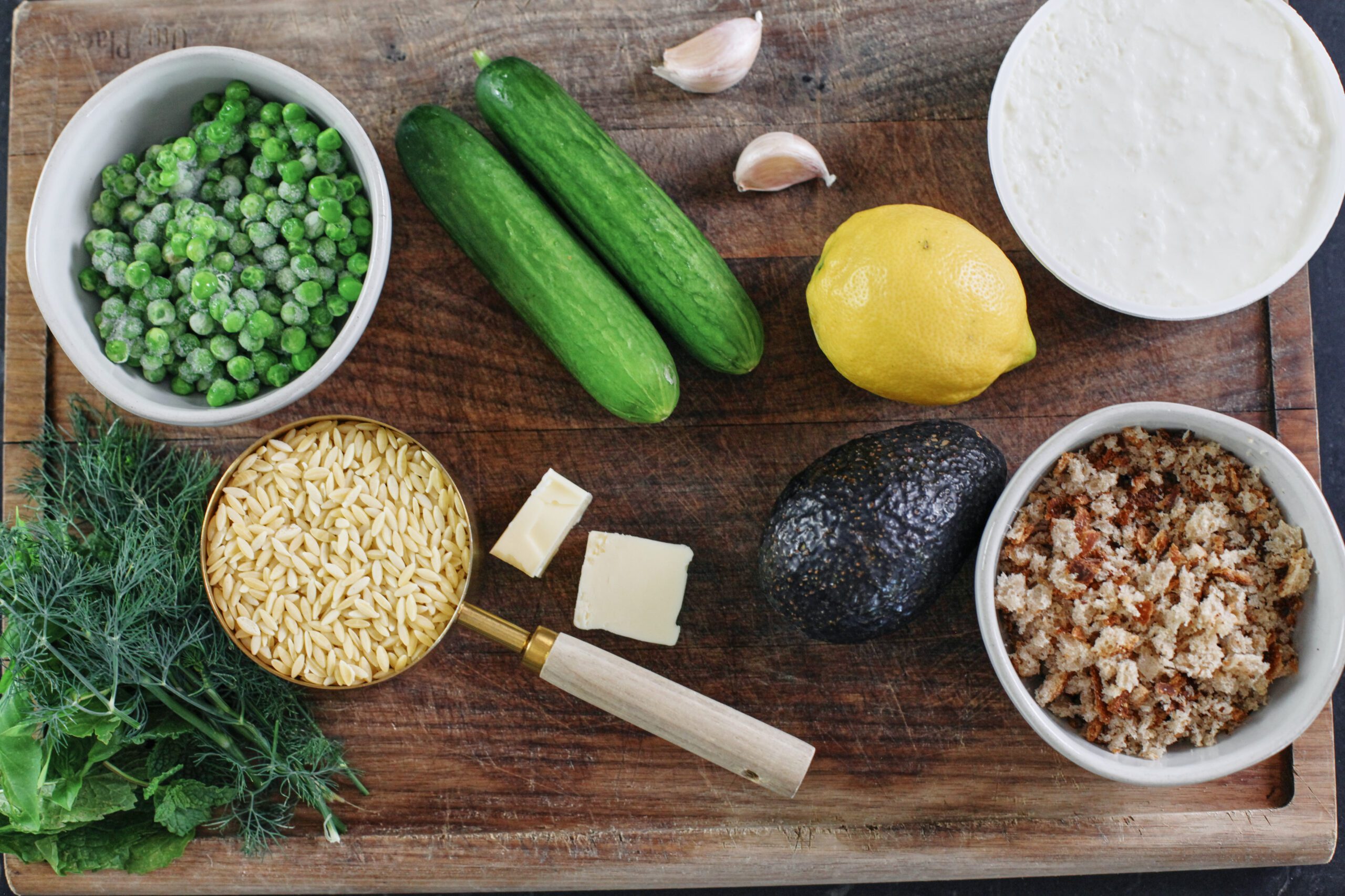 prep for the toasted orzo pasta salad: peas, herbs, orzo, butter, cucumbers, garlic, lemon, avocado, breadcrumbs, burrata/stracciatella