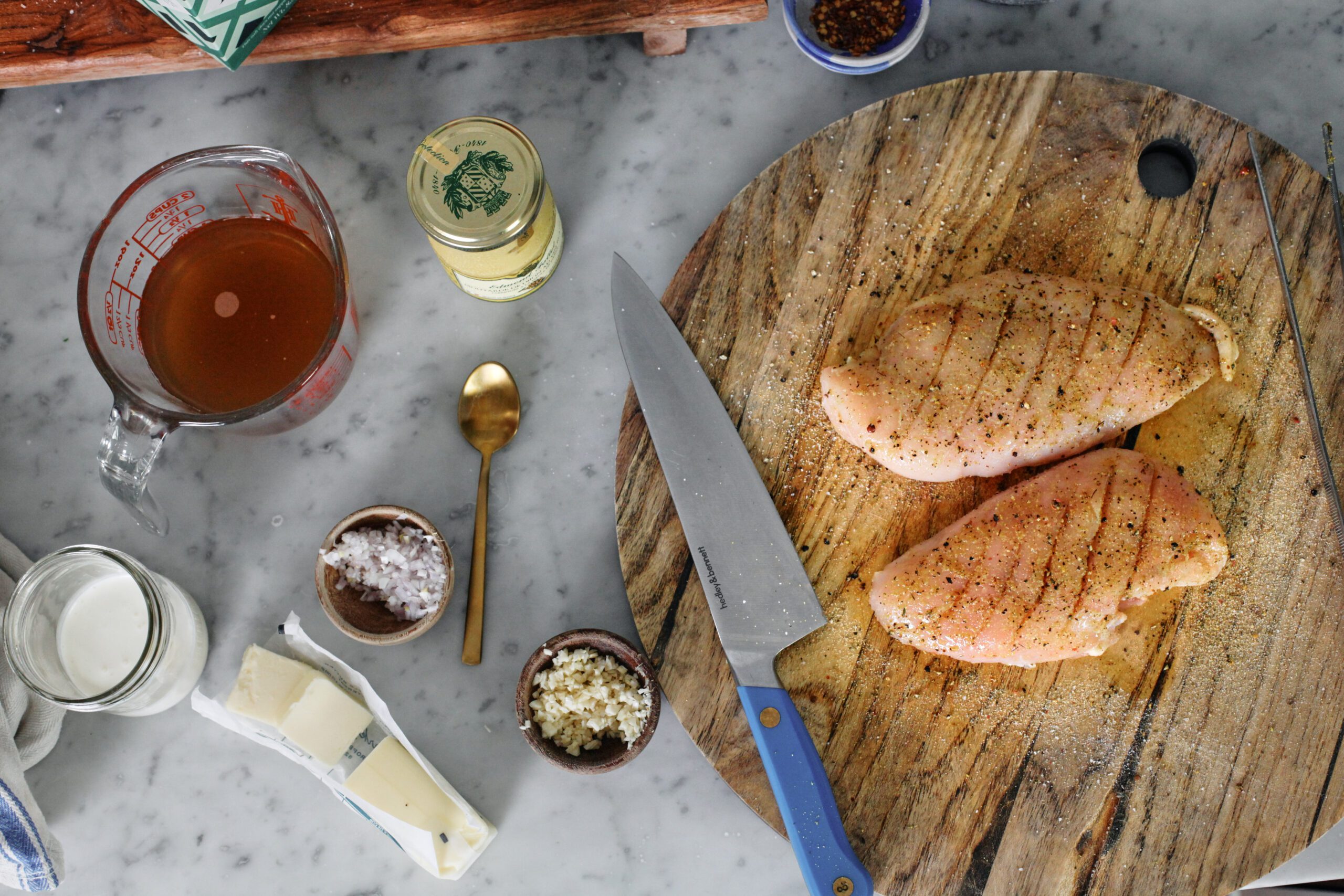 all the prep for this dish: seasoned chicken breast, dijon mustard, minced shallot, minced garlic, chicken broth, butter, cream.