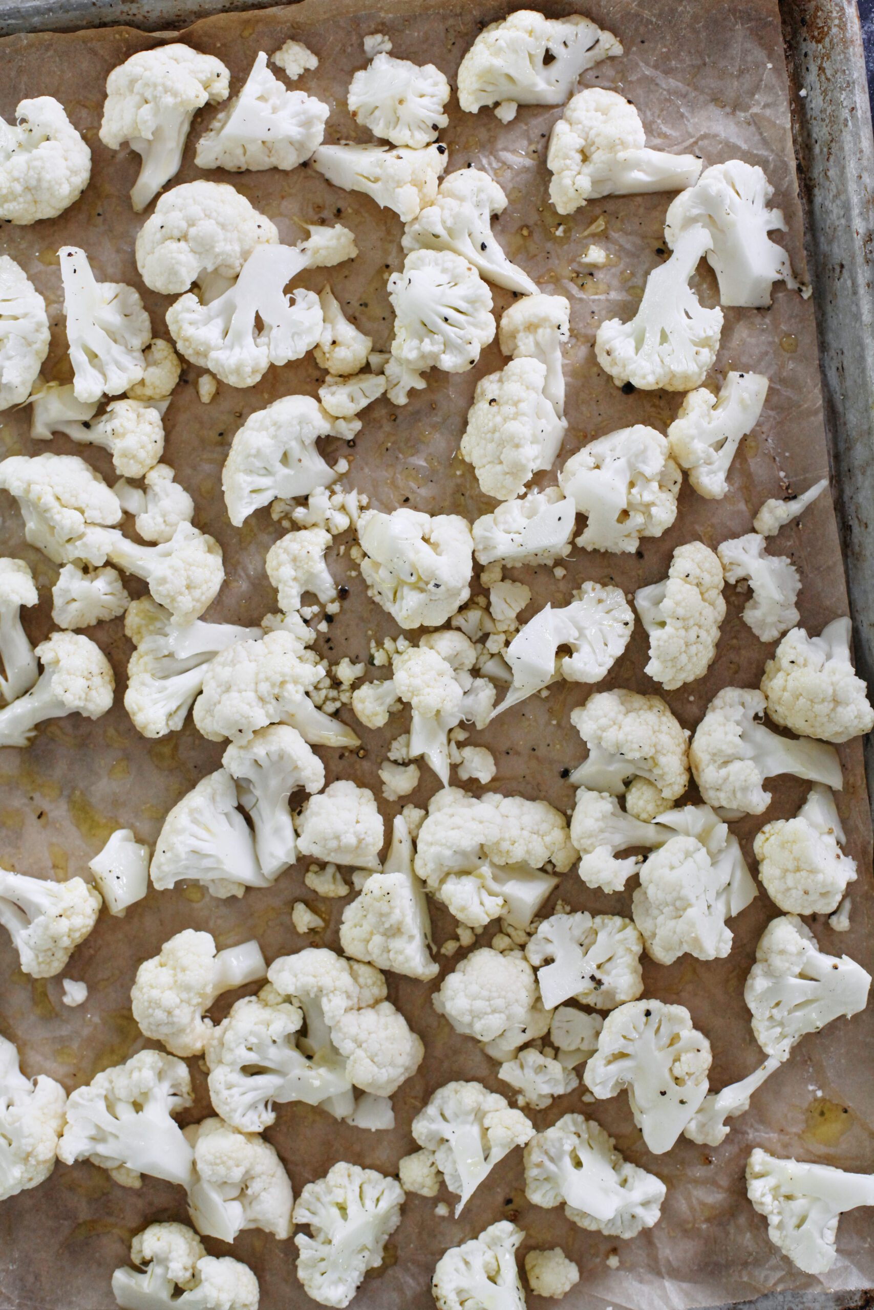 chopped cauliflower on a parchment lined pan