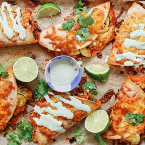 baked chorizo sheet pan tacos served on a pan with limes, cilantro, and jalapeño garlic crema