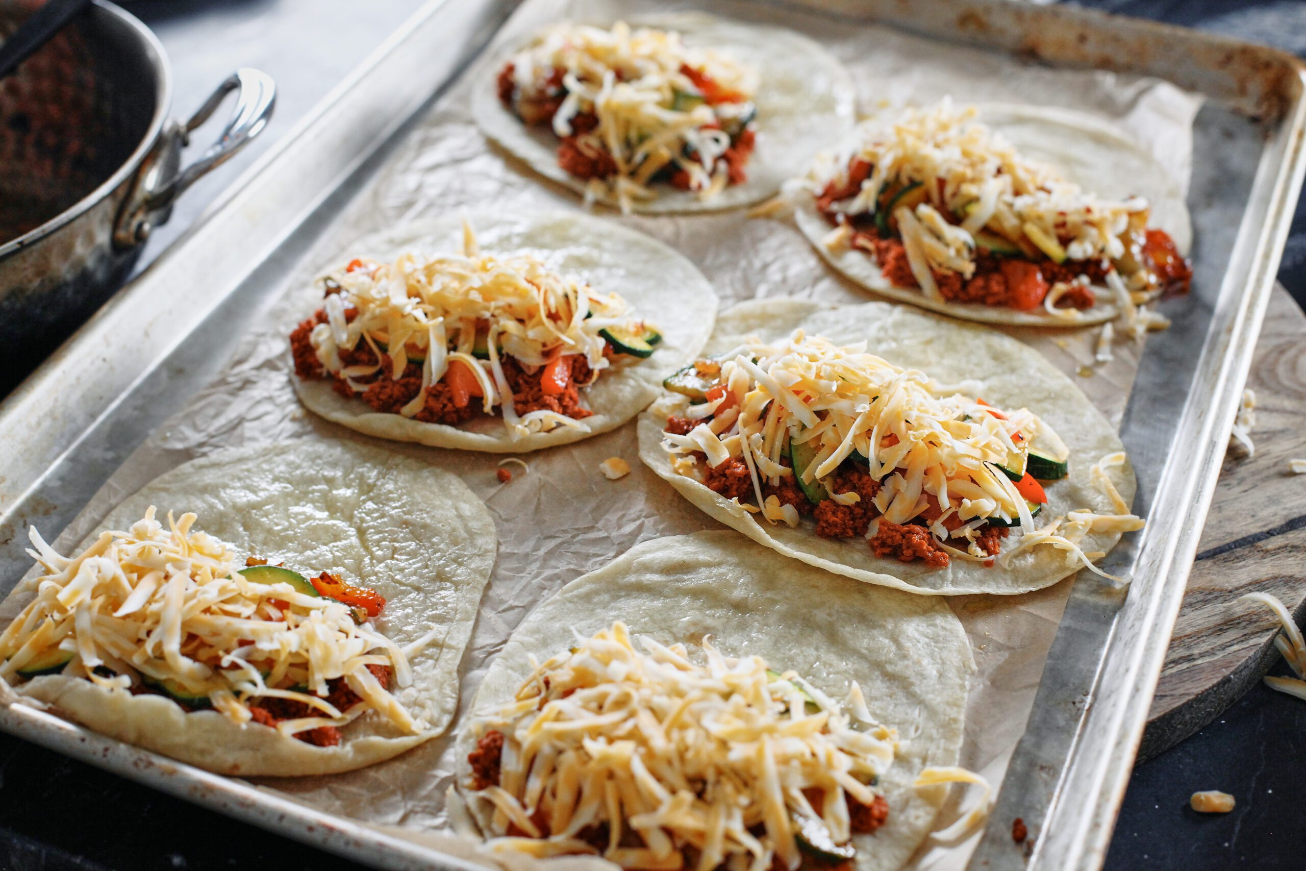 chorizo, veggies, and cheese loaded onto one half of each tortilla (6 tortillas on a sheet pan)