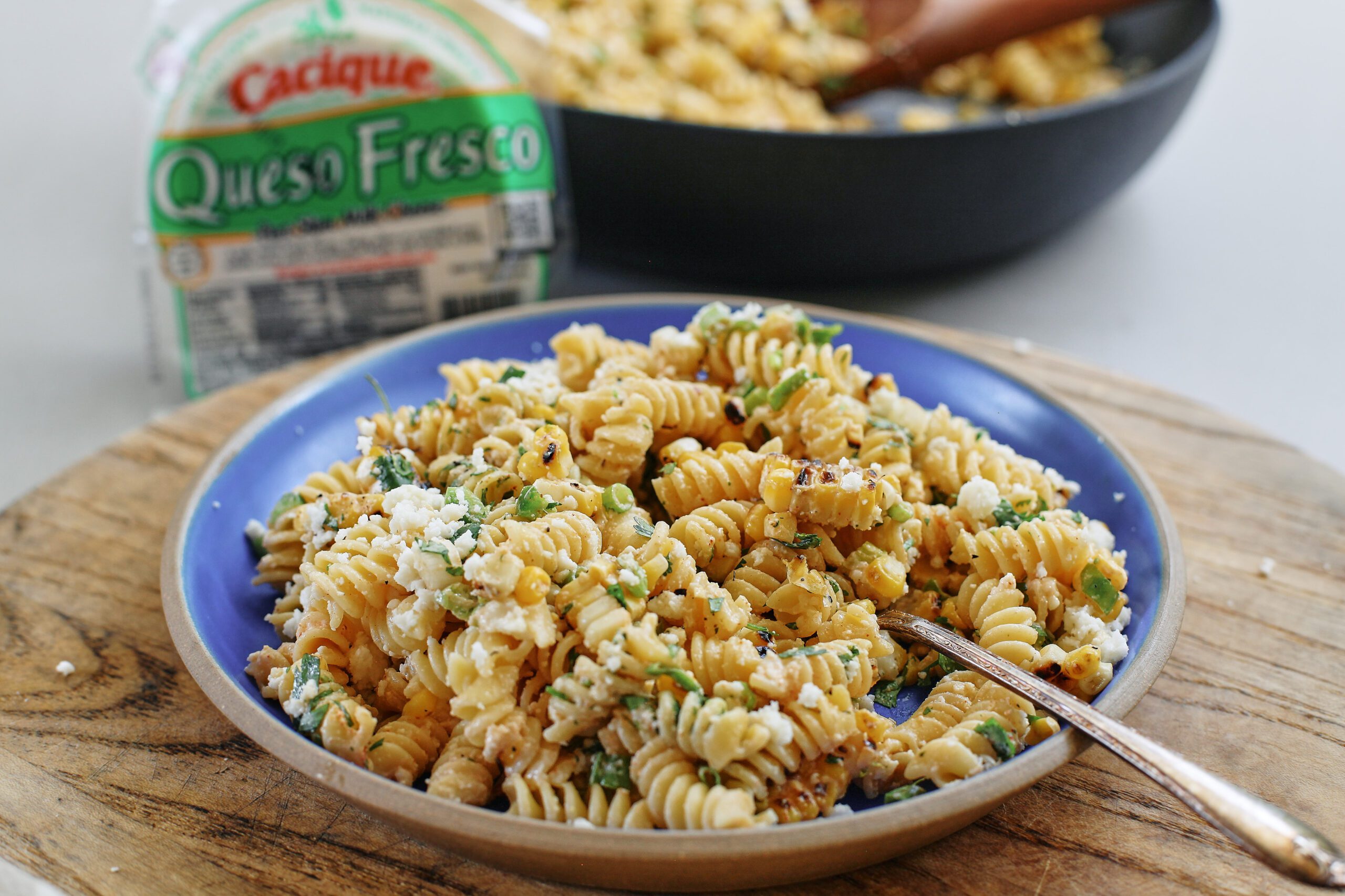 elote pasta salad on a cobalt blue ceramic plate