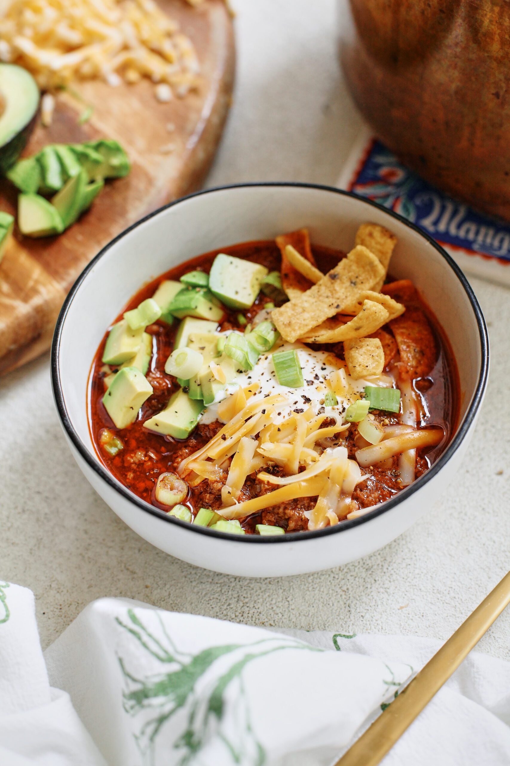 texas style chili topped with sour cream, avocado, green onions, shredded cheese, and fritos