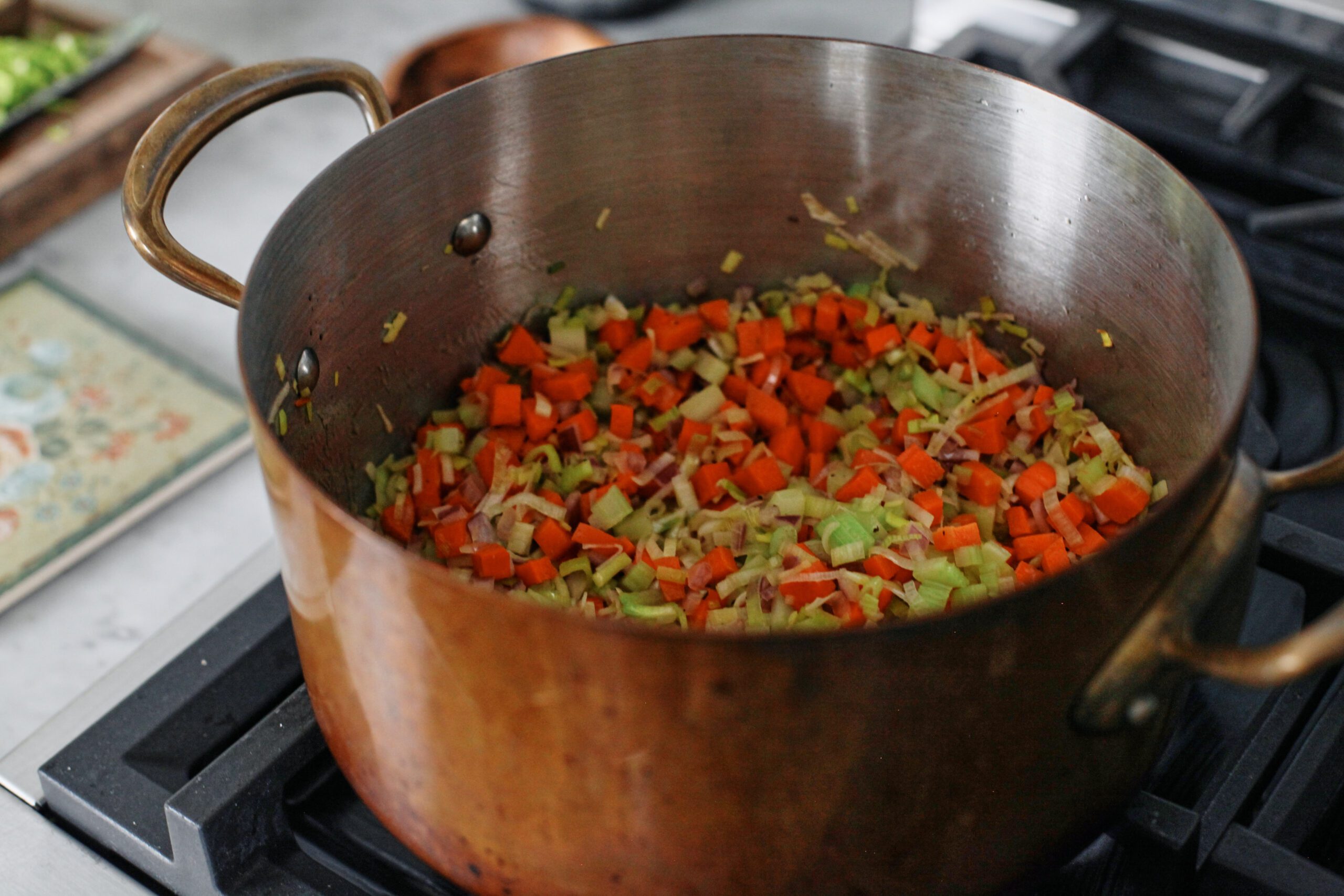 red onion, carrot, celery, leek, and garlic sautéing in a large stock pot