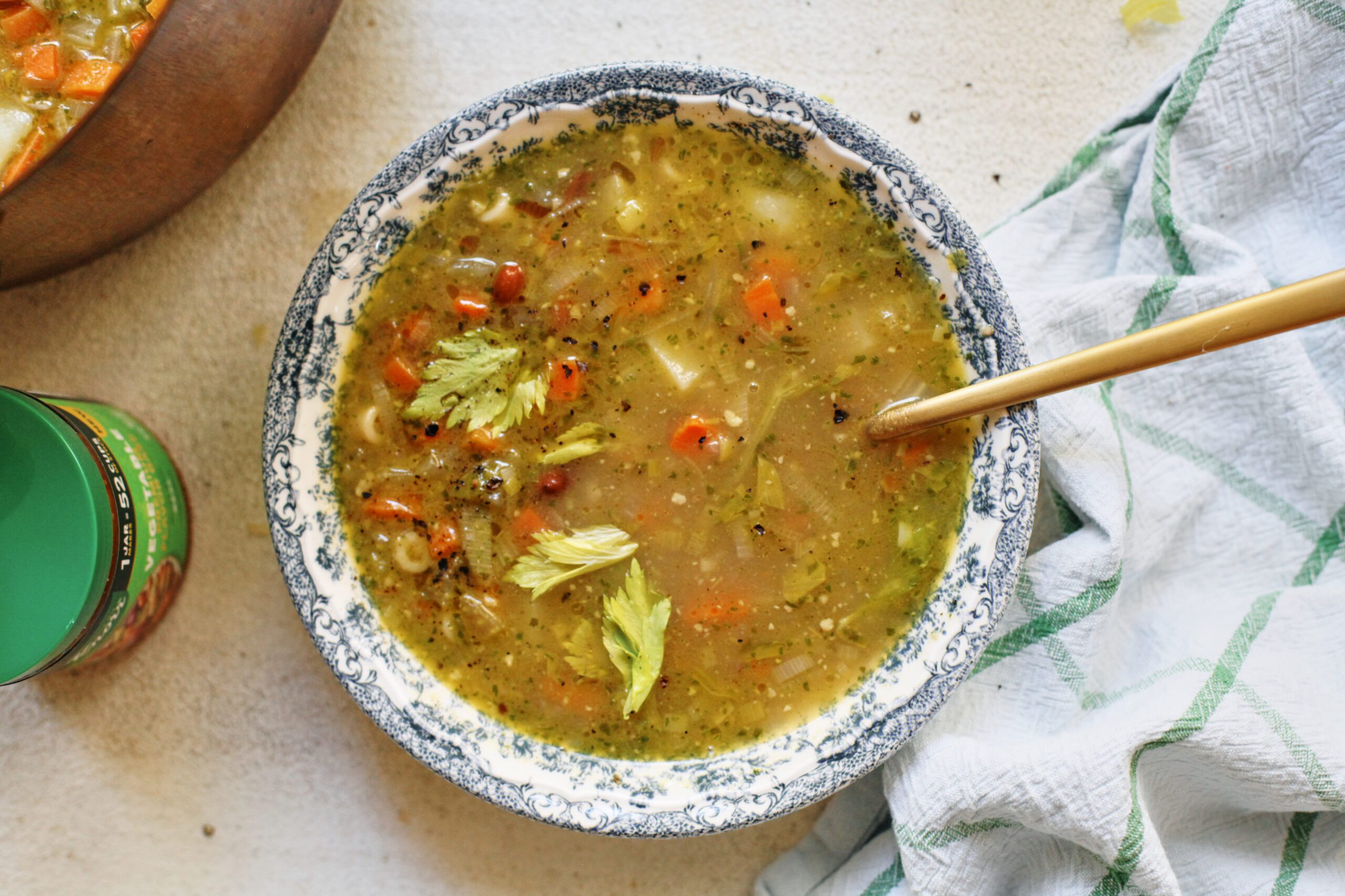 pesto minestrone soup in a white and blue floral-patterned bowl