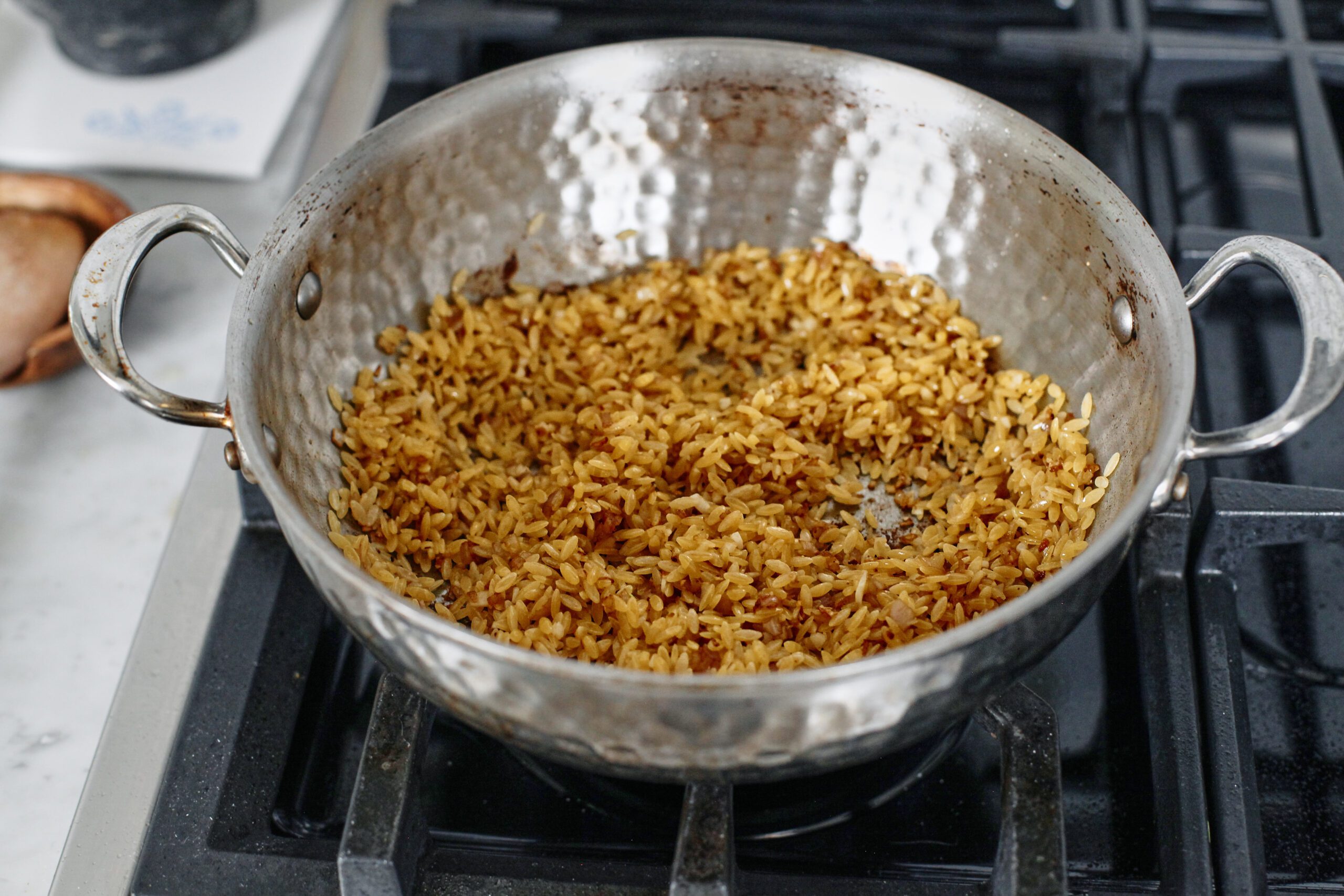 orzo toasting in a large pan with the shallot and garlic