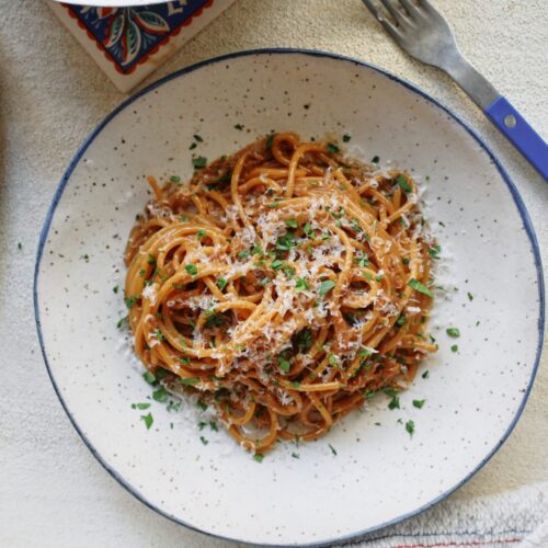 French onion spaghetti in a shallow white bowl with a black rim